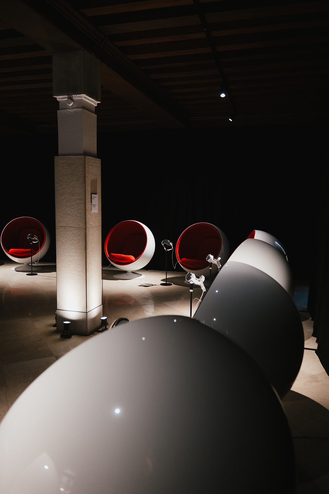 The showroom in Venice: red and white ball chairs arranged between the palazzo columns, an Apple Vision Pro waiting on a stand beside each one